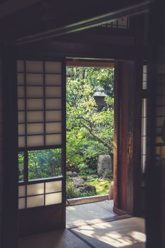 Tranquil scene through shoji doors into a lush Japanese garden.