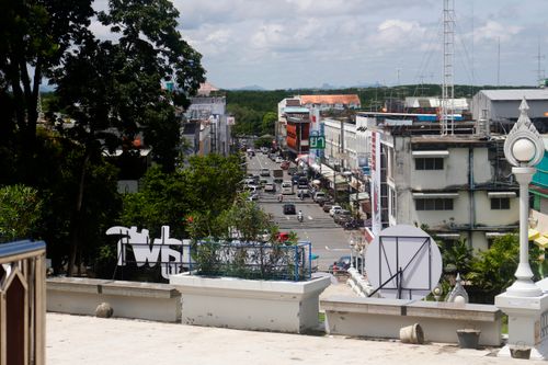 Free A bustling urban street in Thailand with buildings and cars in view, captured on a sunny day. Stock Photo