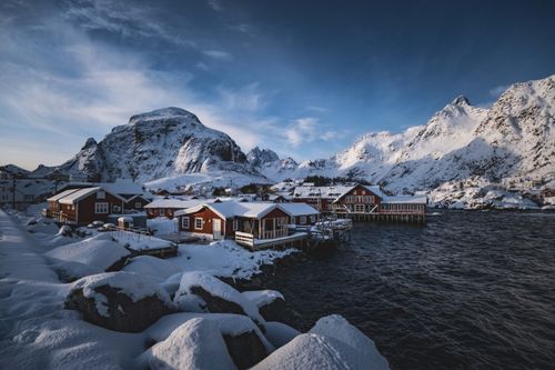 Free Idyllic snowy village in Lofoten Norway with dramatic mountain backdrop. Stock Photo
