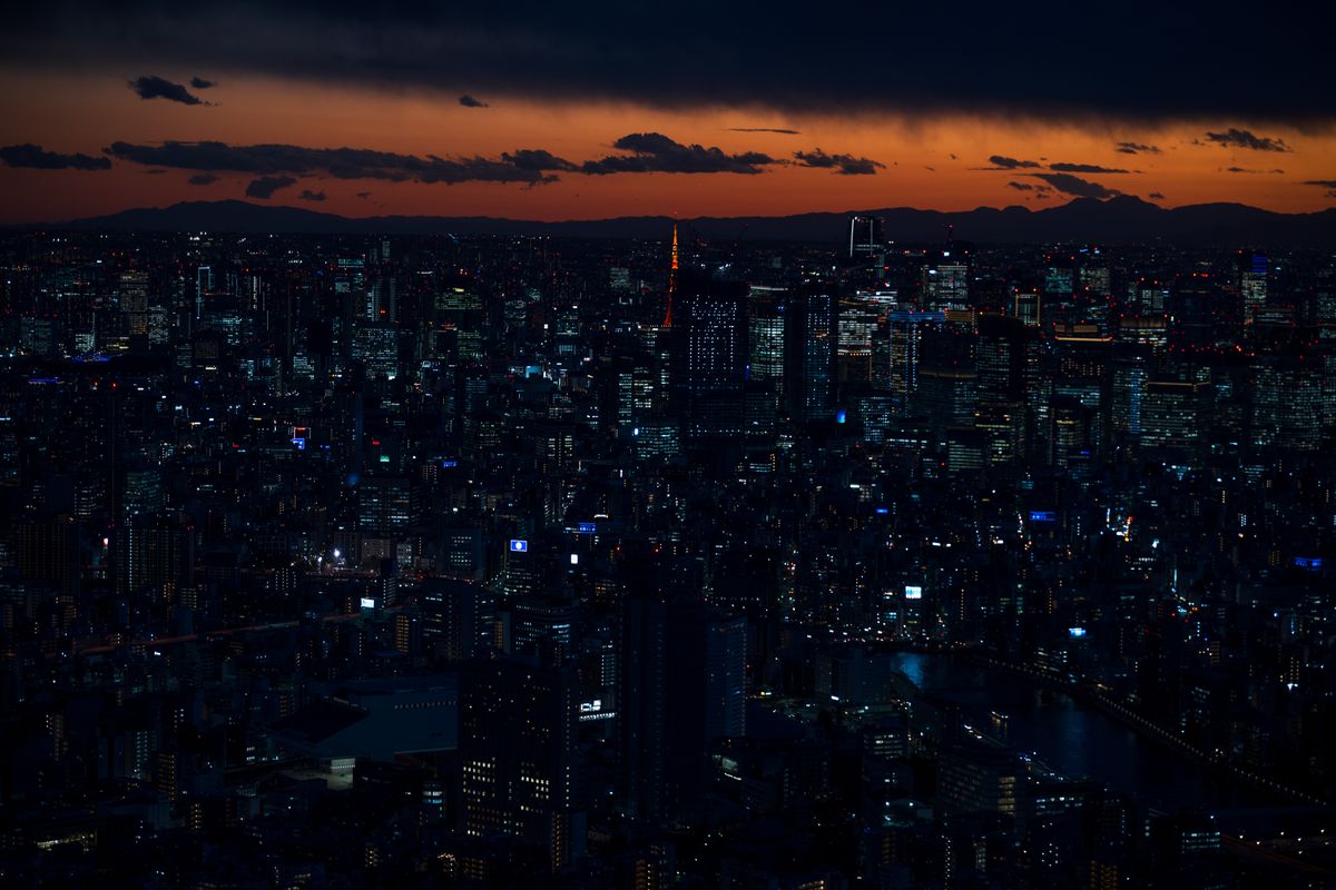 Unde te cazezi în Tokyo - panoramă a orașului la asfințit, cu zgârie-nori luminați