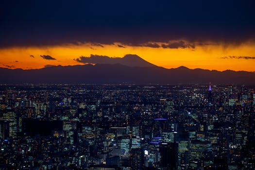 Breathtaking view of Tokyo skyline with Mount Fuji silhouetted against a vibrant sunset sky.