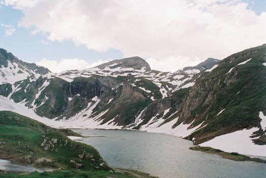 Breathtaking view of snow-capped mountains and serene lake in Austria's Alps.