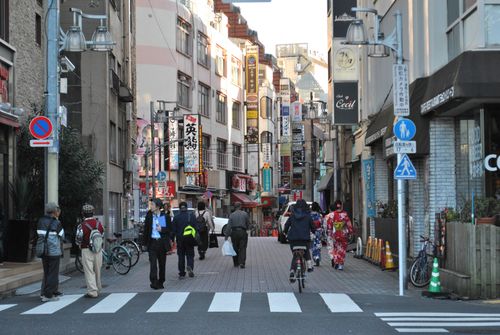 Free Vibrant Tokyo street scene with pedestrians, traditional clothing, and colorful storefronts. Stock Photo