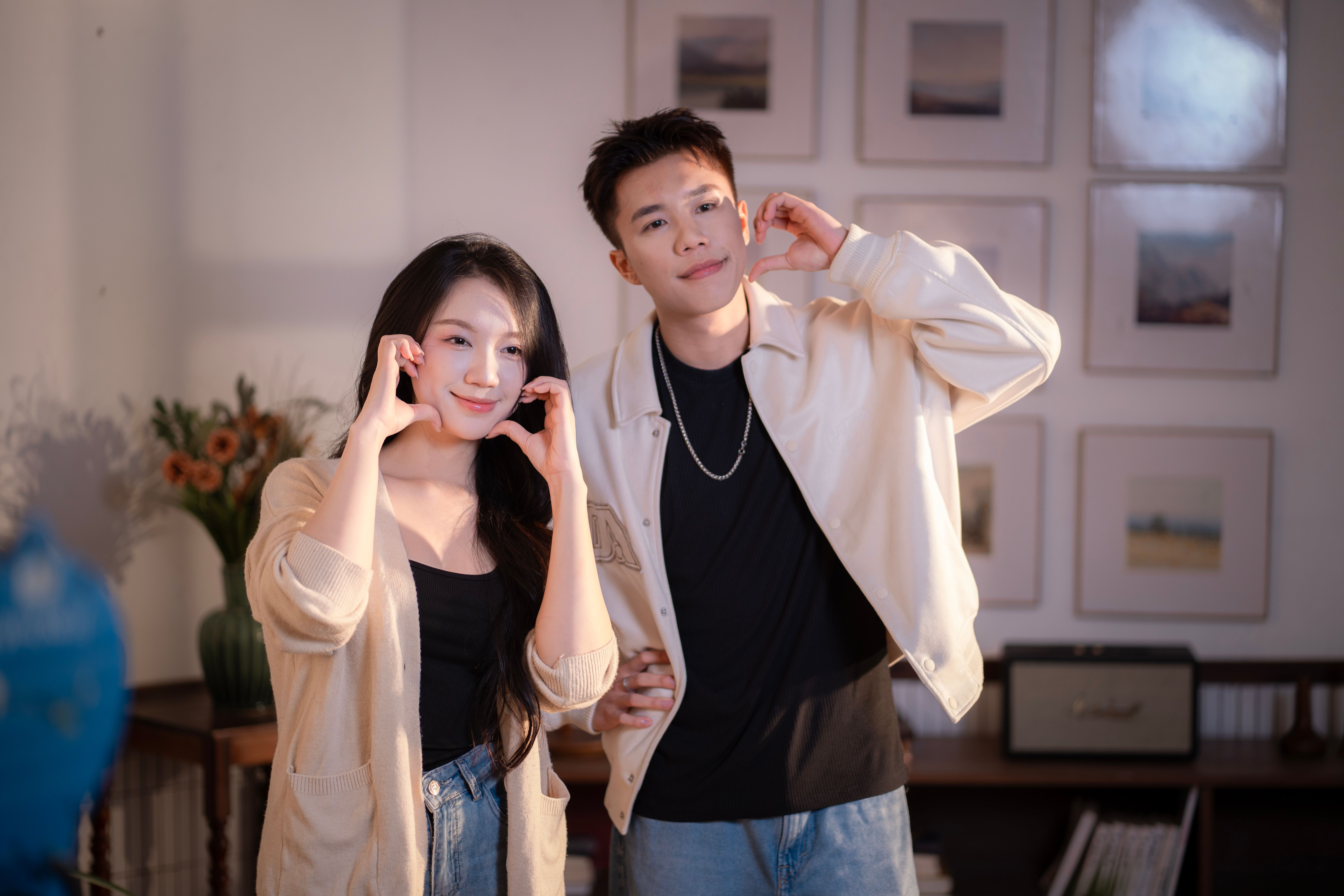 틱톡 스타일 숏폼 영상 스크린샷, 임라라 챌린지 중 젊은 커플이 배에 귀 기울이는 장면, 밝고 경쾌한 BGM 효과와 하트 이모지 오버레이