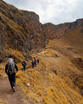Hikers traverse a rugged path in the Andes mountains near Ollantaytambo, Peru.