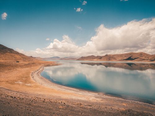 Free Tranquil lake reflecting clouds with mountains in the background, showcasing natural beauty. Stock Photo