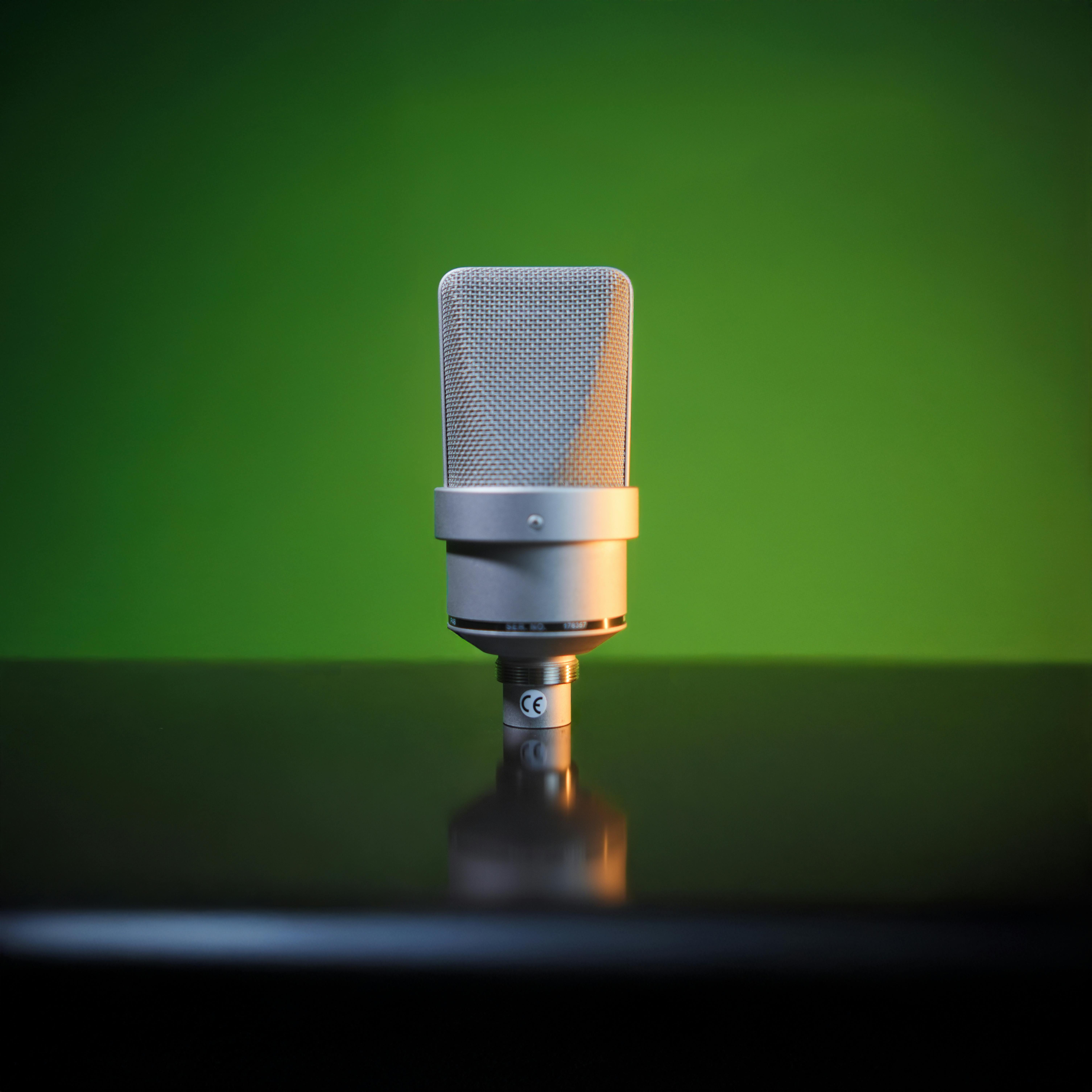 Kostenlos Nahaufnahme eines Studiomikrofons mit grünem Hintergrund, ideal für visuelle Elemente bei Podcasts oder Musikaufnahmen. Stock-Foto