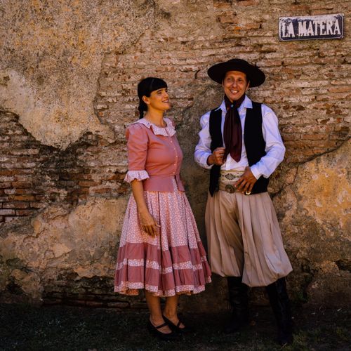 Free A couple dressed in traditional Argentine attire against a rustic brick wall. Stock Photo