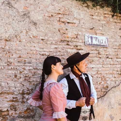 Free Couple in traditional dress posing by rustic wall in Chascomús, Buenos Aires. Stock Photo