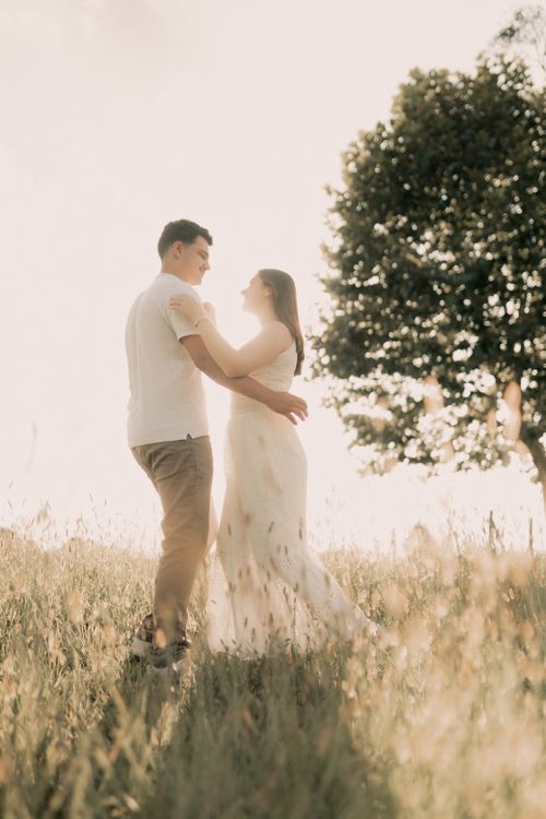Free A couple enjoys a romantic dance in a sunlit meadow, surrounded by nature's beauty. Stock Photo