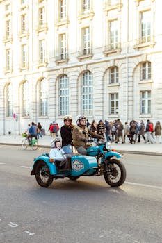 A family enjoys a vintage sidecar motorcycle ride in Paris, showcasing urban street life.