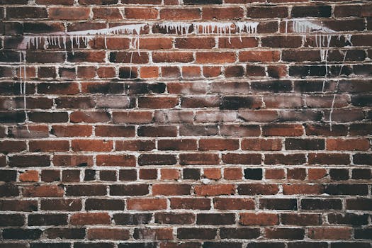 A close-up of a red brick wall with white paint drippings, offering a textured urban background.