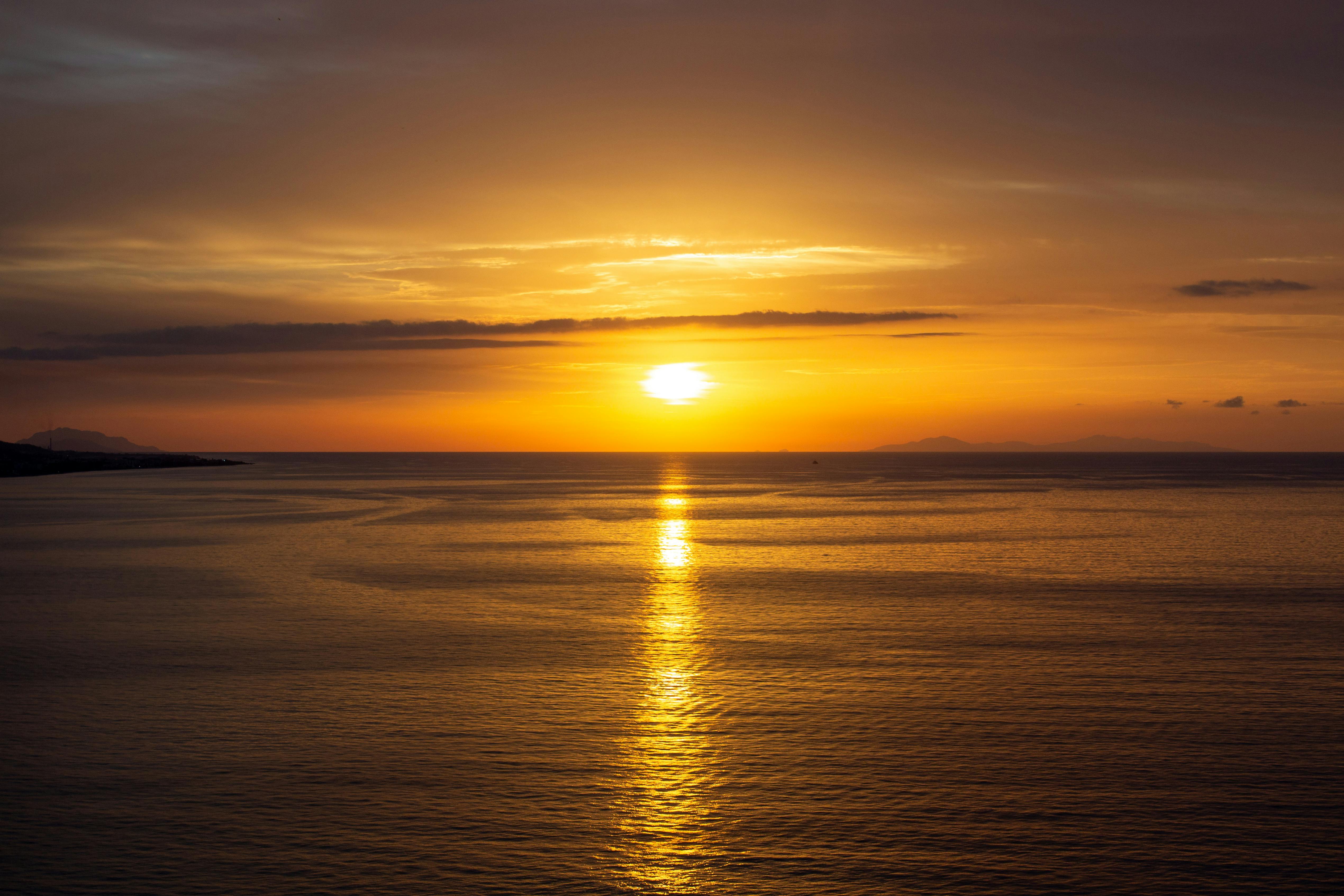 Breathtaking sunset casting golden reflections on the serene ocean waters.