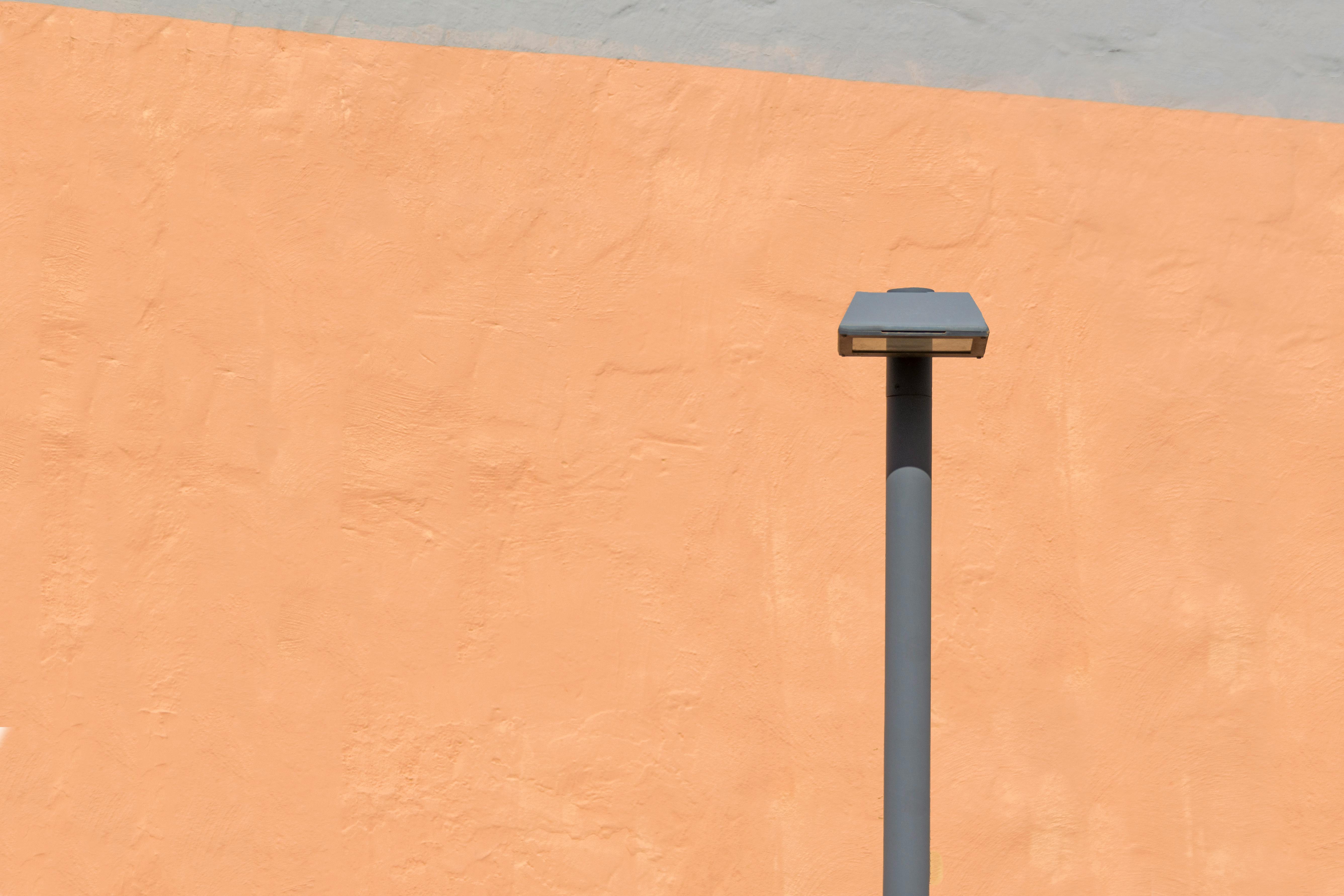 бесплатная Минималистский вид уличного фонаря на фоне яркой оранжевой стены. Идеально подходит для современных тем дизайна. Стоковое фото