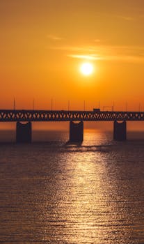 Silhouette of Øresund Bridge against a vivid sunset in Malmö, Sweden.