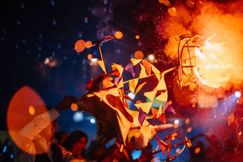 Free Dynamic festive scene with fire performer and colorful decorations in vibrant light. Stock Photo