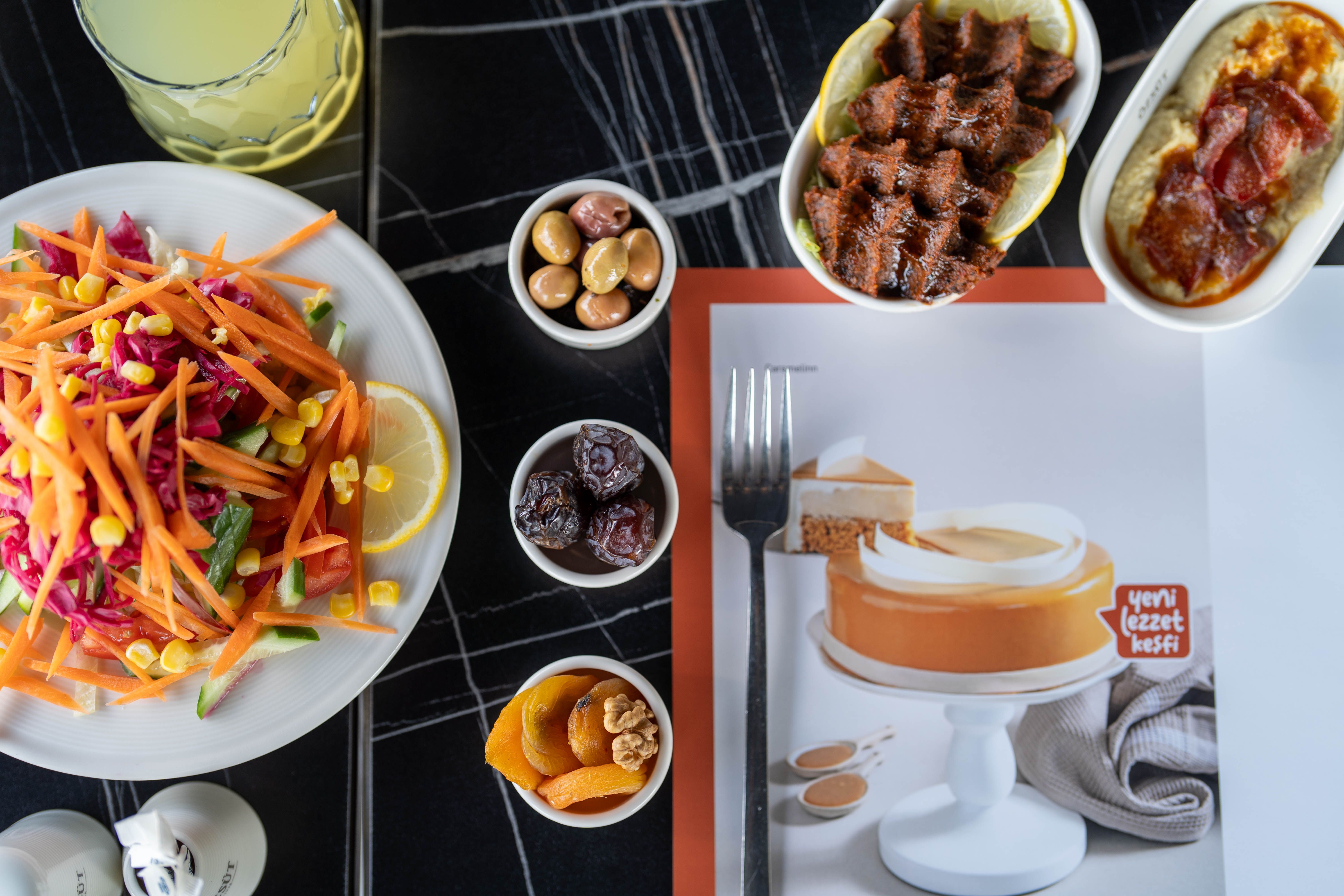 Top view of a vibrant Turkish meal with salads, appetizers, and dessert on a table.