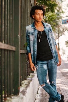 圣保罗，一位时尚的年轻人随意地靠在户外栅栏上