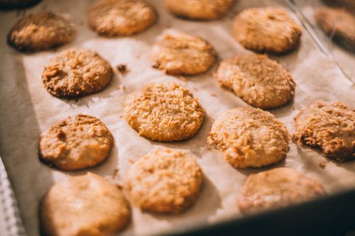 Free Close-up of freshly baked cookies on a parchment-lined tray, showcasing a golden, crispy texture. Stock Photo