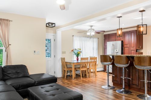Free Bright and spacious kitchen and living room interior featuring wooden floors and modern furniture. Stock Photo