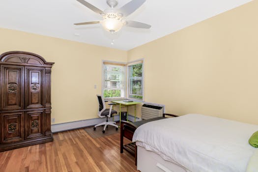 Spacious minimalist bedroom featuring a wooden wardrobe, desk, and modern chair. Perfect for a peaceful retreat.