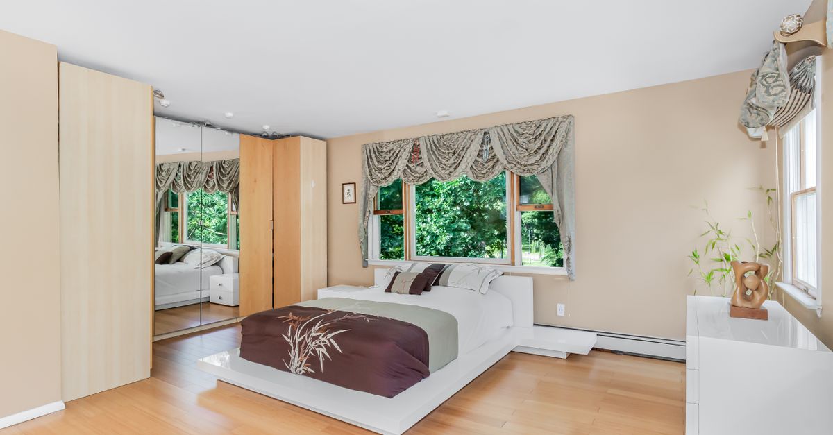 A well-decorated bedroom featuring modern design, large windows, and elegant decor.