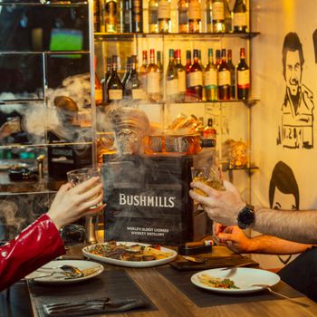 Warm atmosphere in a bar in Erbil featuring Bushmills whiskey and appetizers. Ideal for festive gatherings.