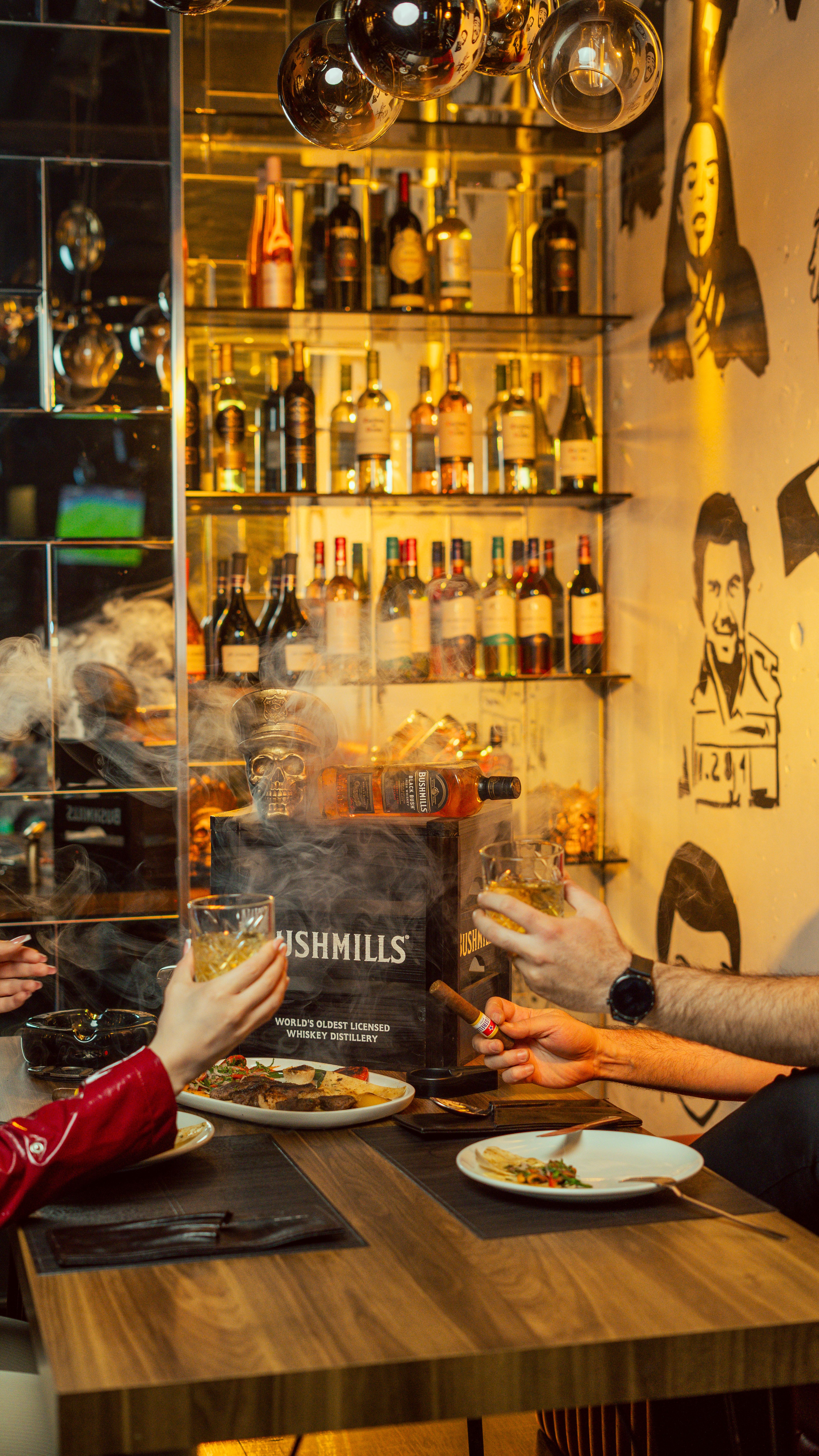 Gratis Venner deler drinks og mad i en livlig whiskybar i Erbil, Irak. Lagerfoto