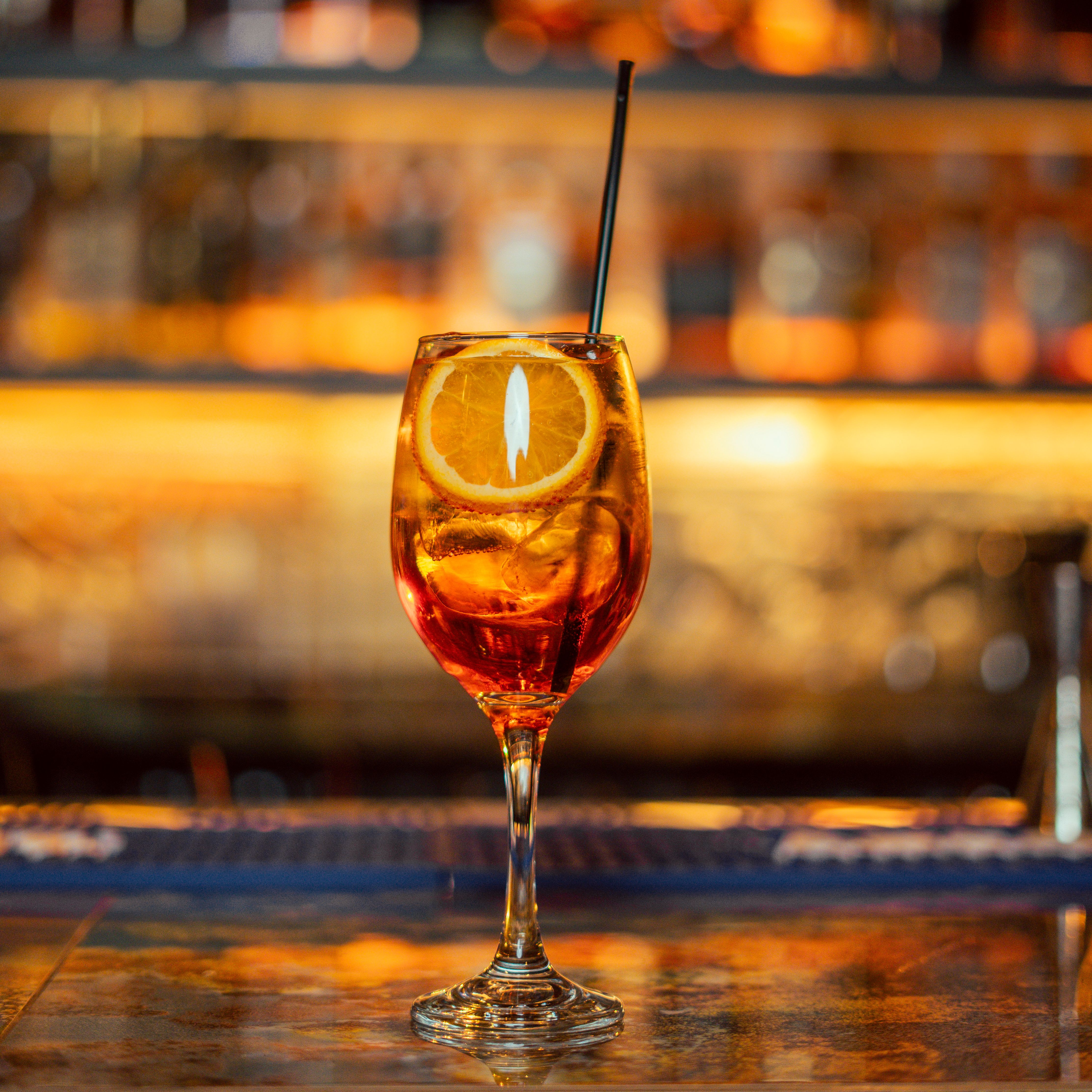 Gratis Elegant Aperol Spritz cocktail garneret med appelsinskive, fanget på en stilfuld Erbil bar. Lagerfoto