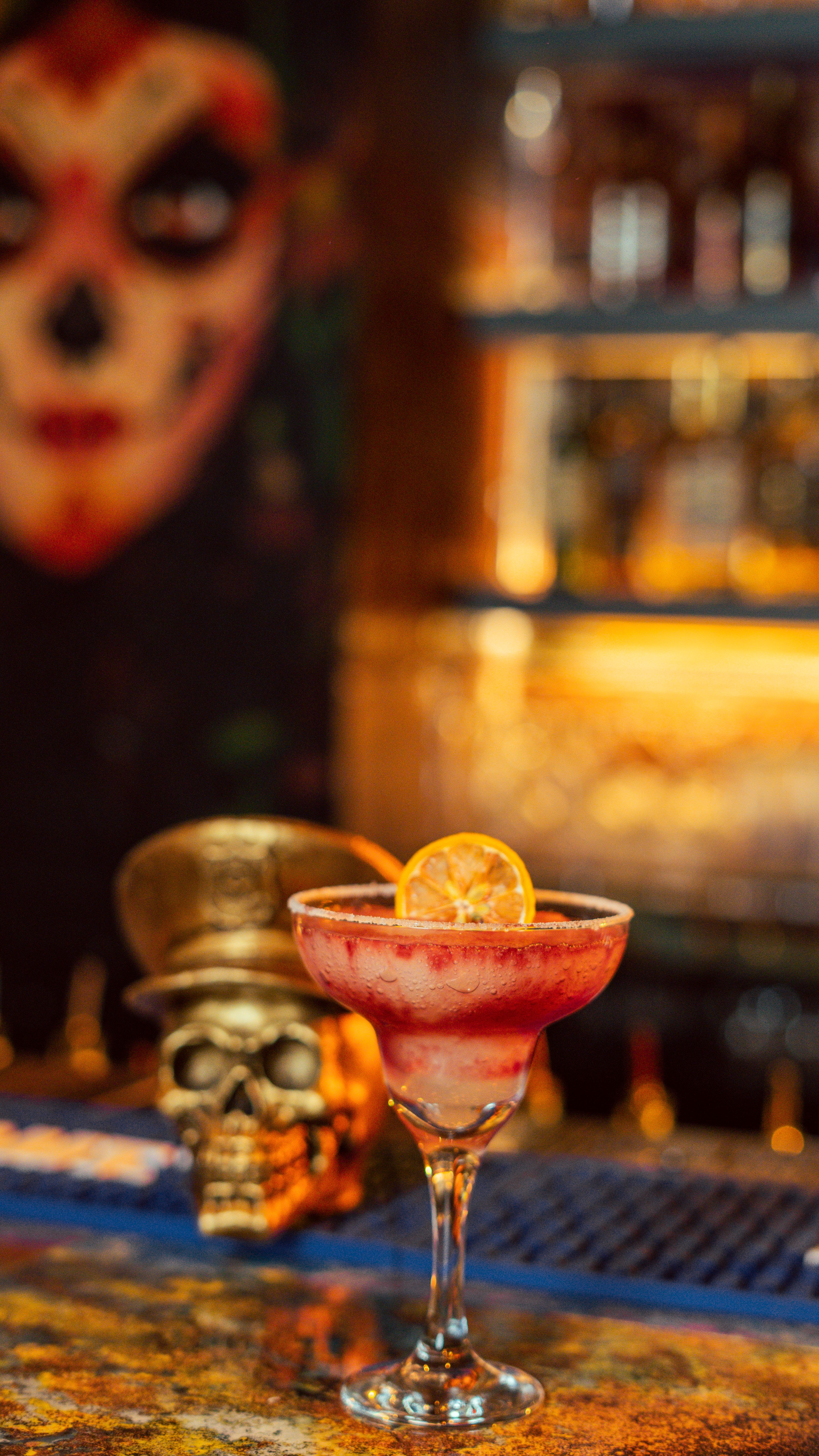 Gratis En farverig cocktail med en skive citrusgarniture i en temabar med kunstnerisk indretning. Lagerfoto