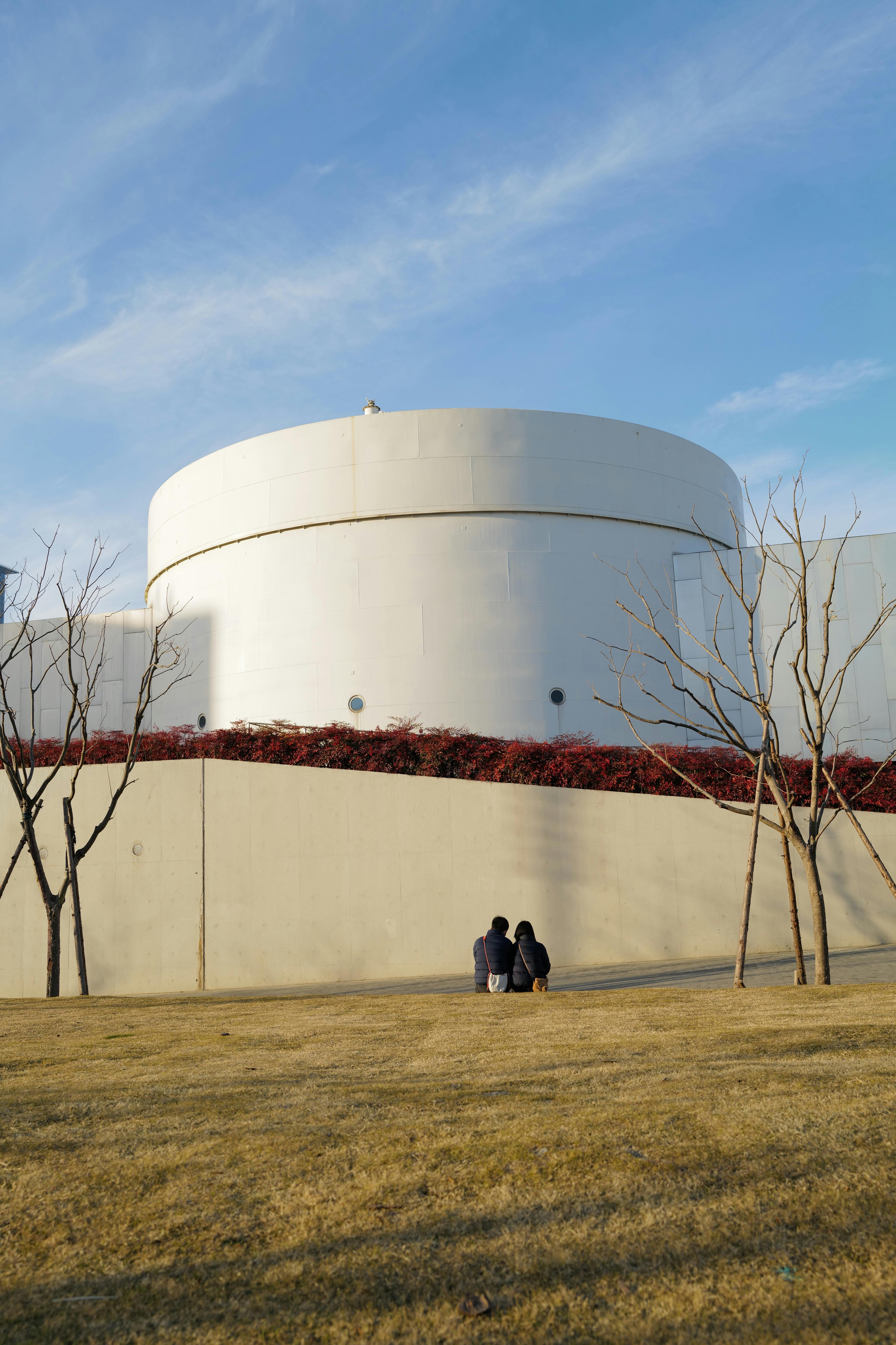 A couple sitting in a Shanghai park, enjoying the serene surroundings and modern architecture.