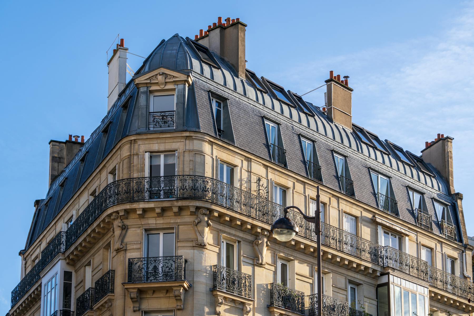 Classic Haussmann building, Paris — wrought iron balconies and slate rooftop