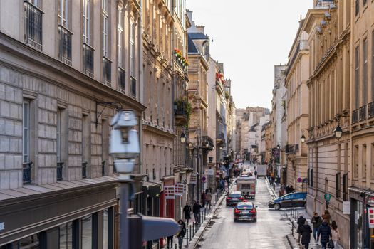 A picturesque Paris street featuring classic Haussmann architecture and a bustling cityscape.