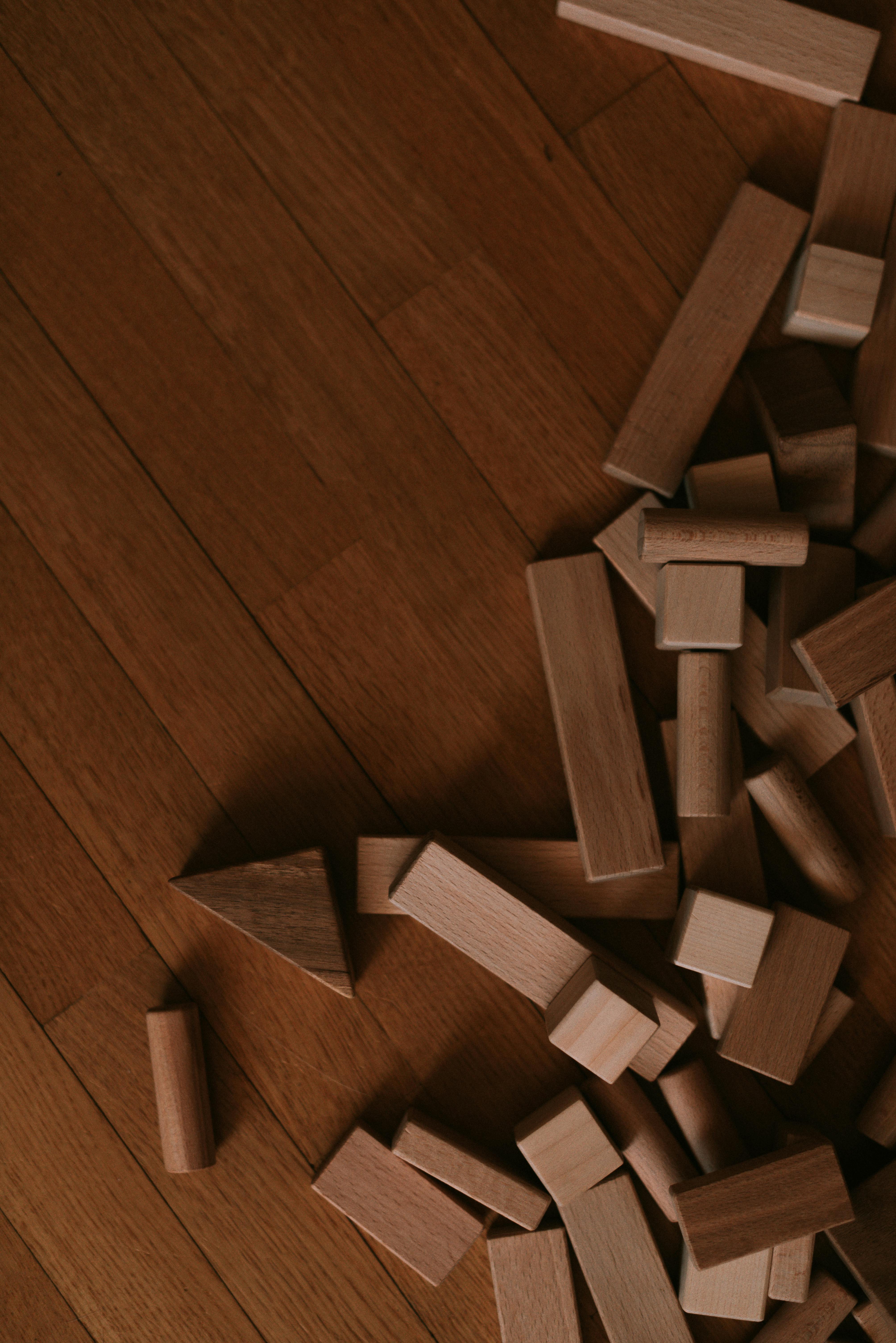 Scattered wooden blocks on a hardwood floor, showcasing playful creativity.