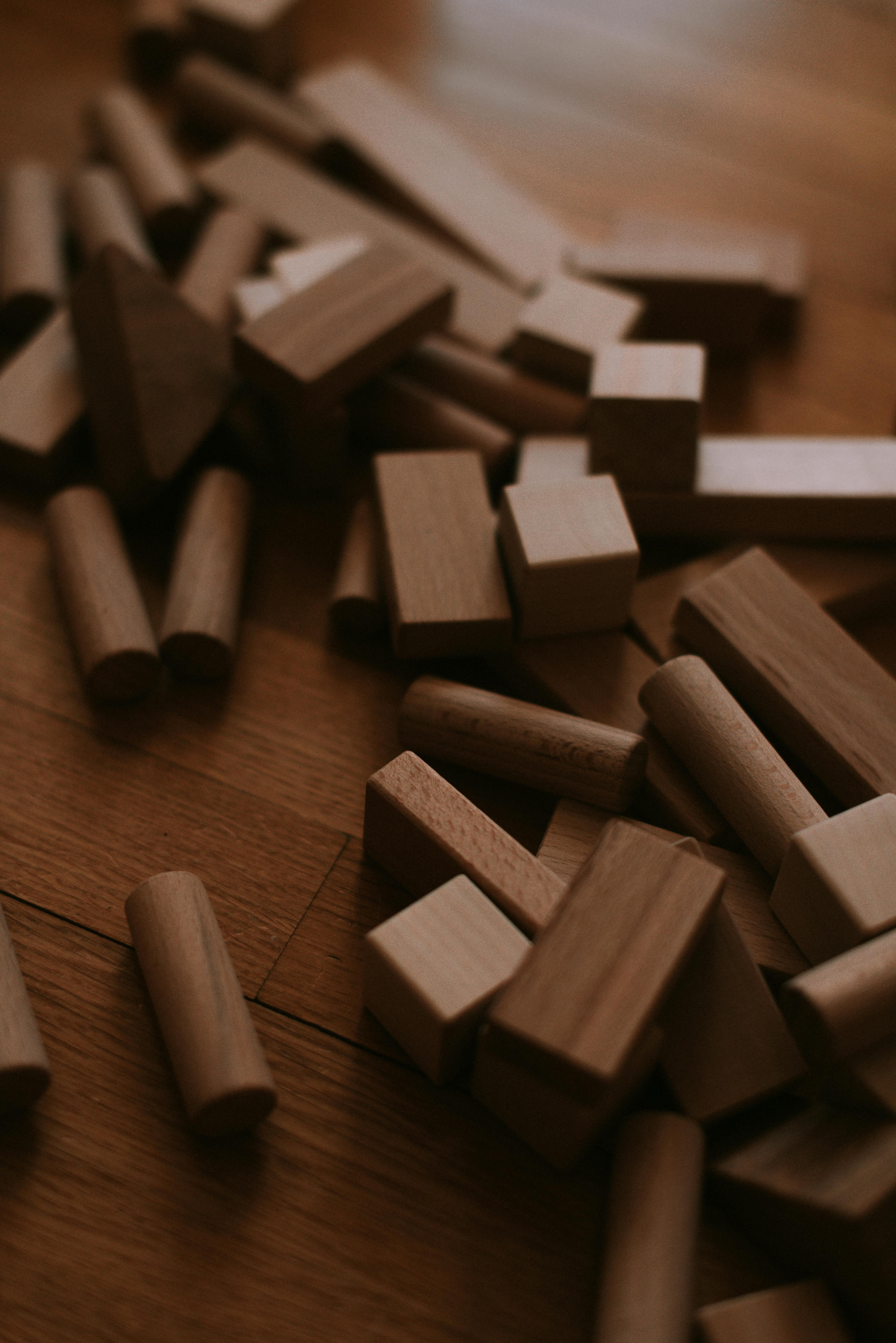 Artistic arrangement of wooden blocks on a warm-toned hardwood floor. Perfect for creative projects.