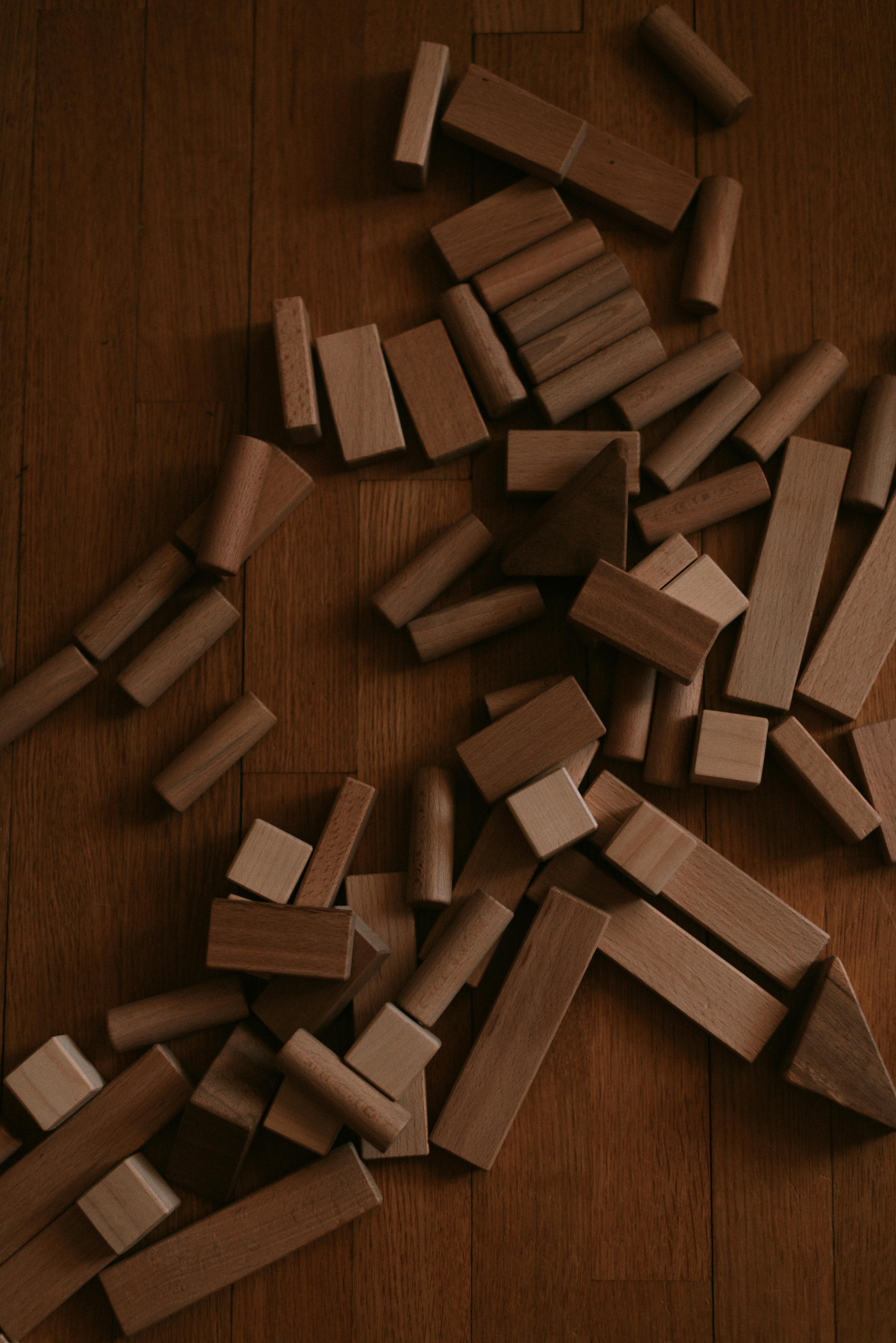 A collection of wooden blocks scattered on a hardwood floor, suitable for educational themes.