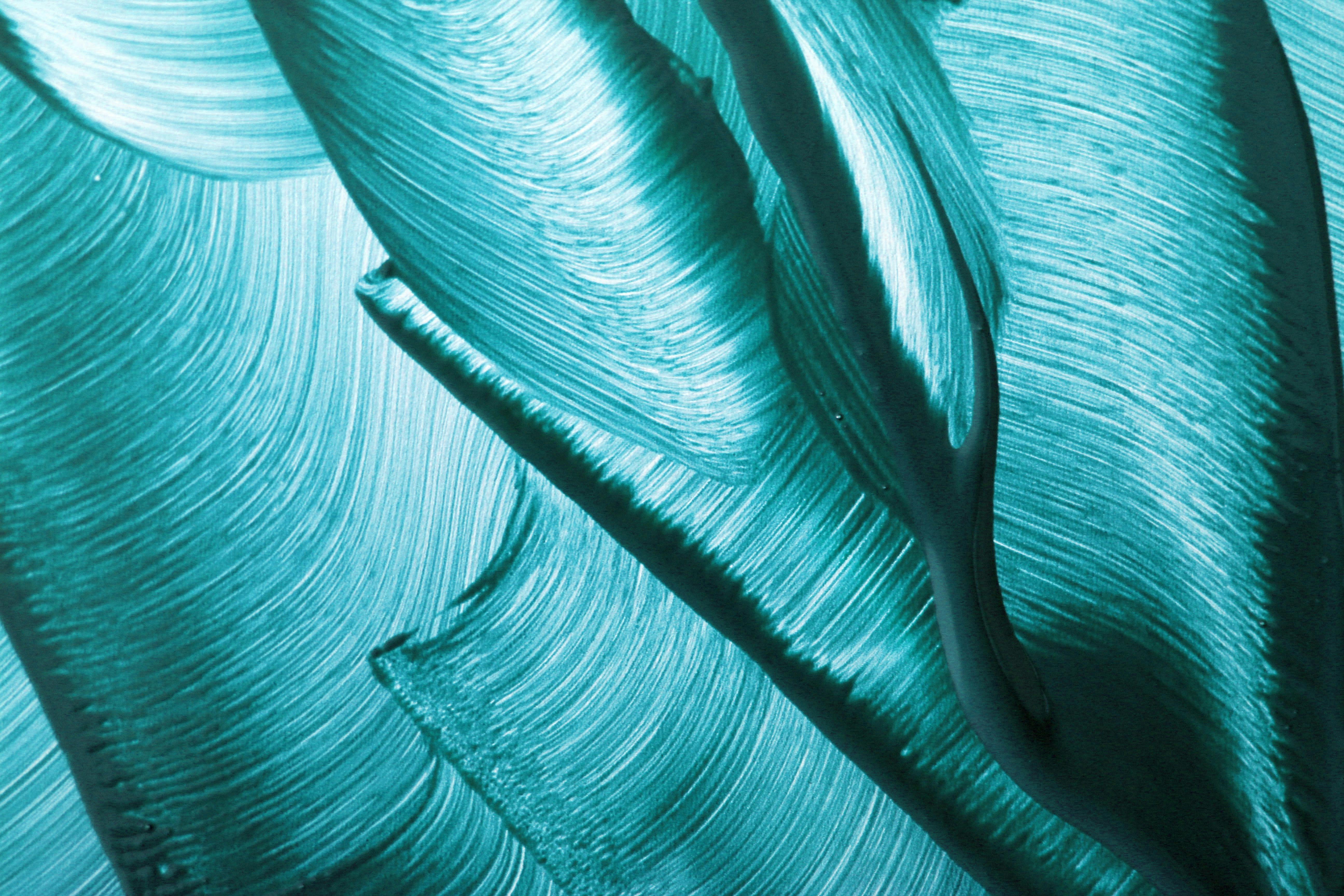 Dynamic abstract painting in vibrant turquoise hues showcasing fluid brushstrokes.