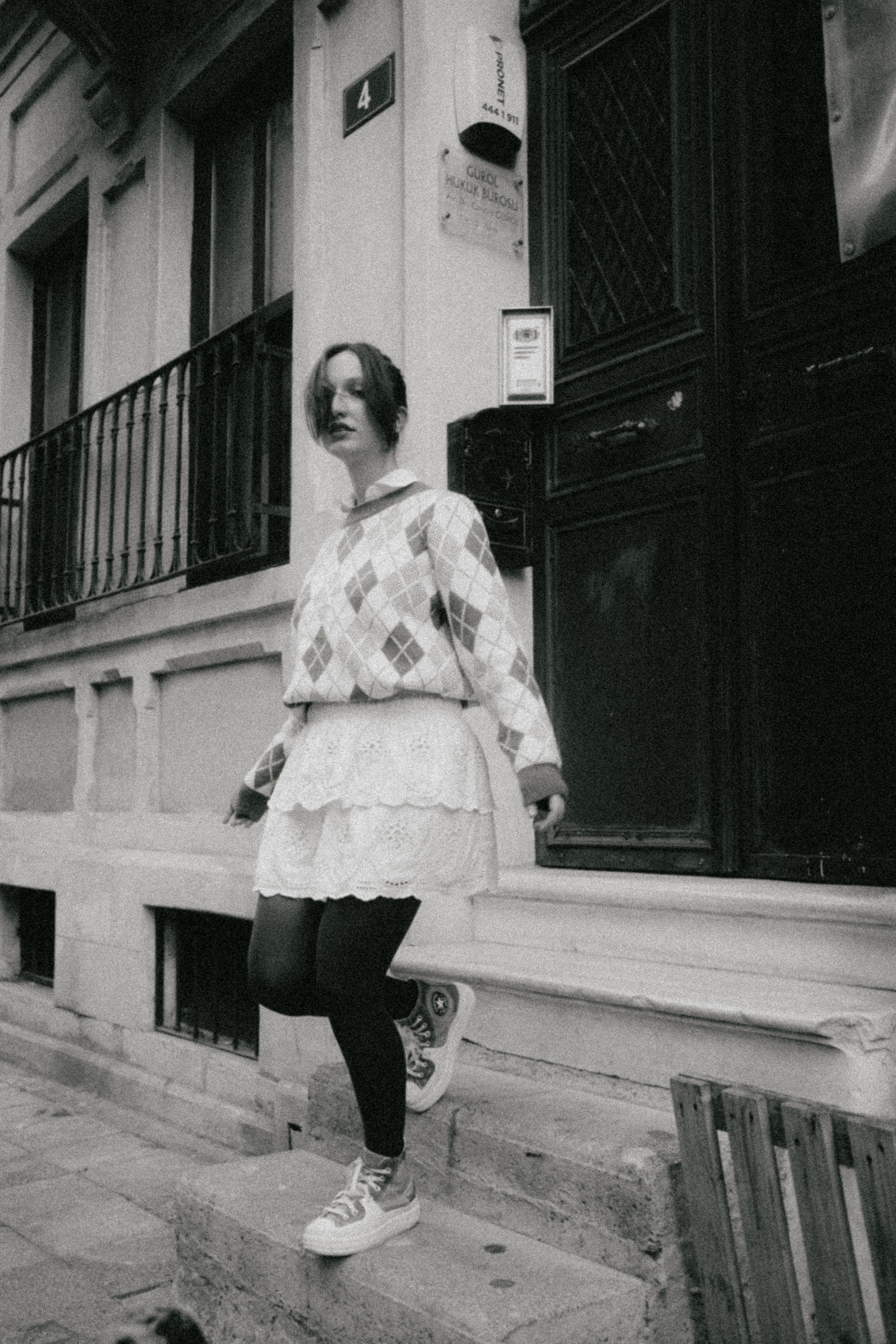 Black and white image of a young woman in a city setting.