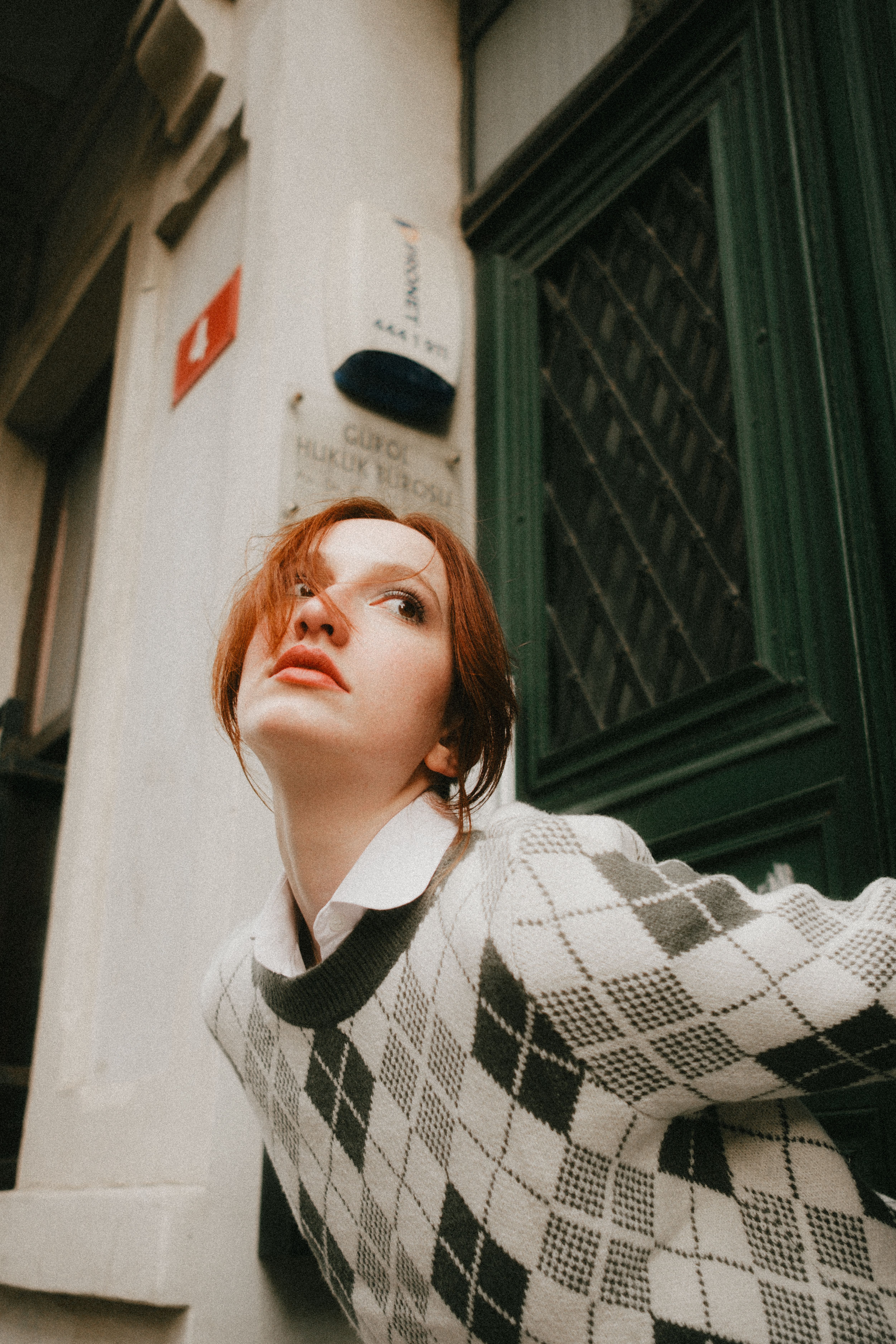 Stylish woman poses outdoors in a chic urban location.