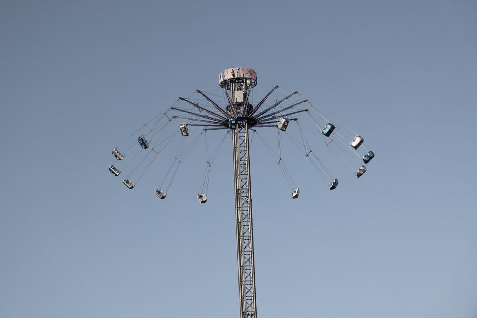 High swing ride in motion at amusement park against a clear sky.