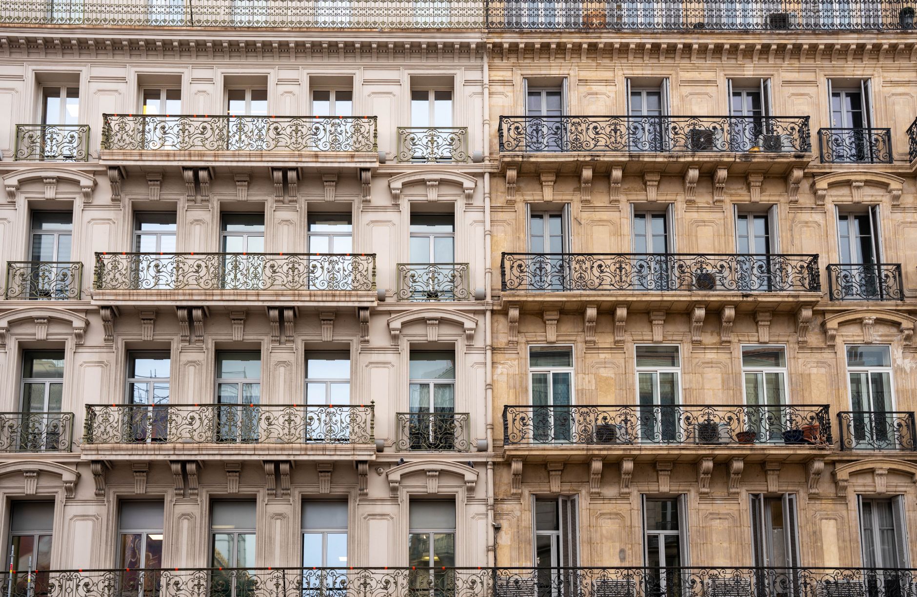 Façade élégante d'un immeuble toulonnais aux balcons en fer forgé.