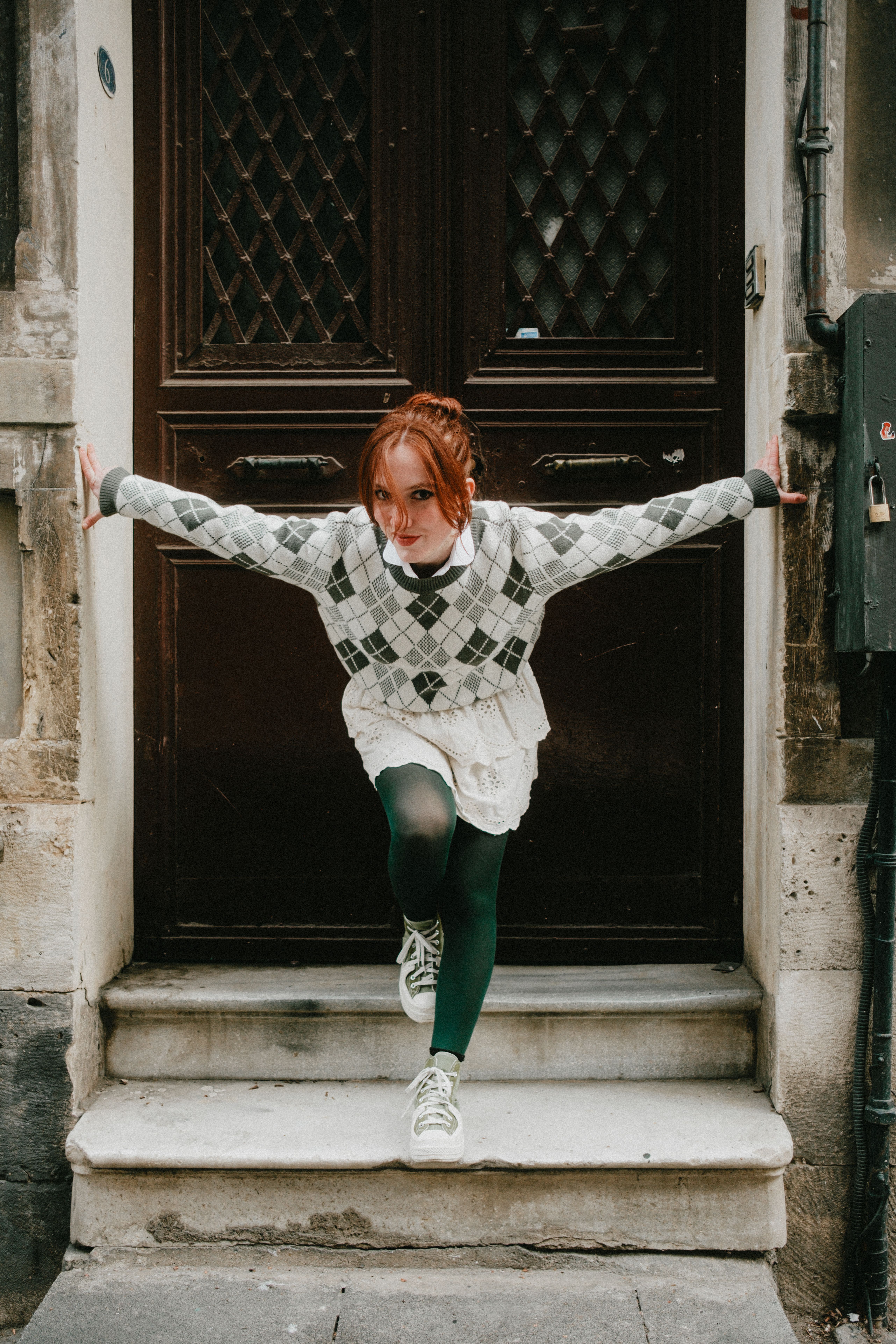 Young woman posing dynamically at a doorway in Istanbul.