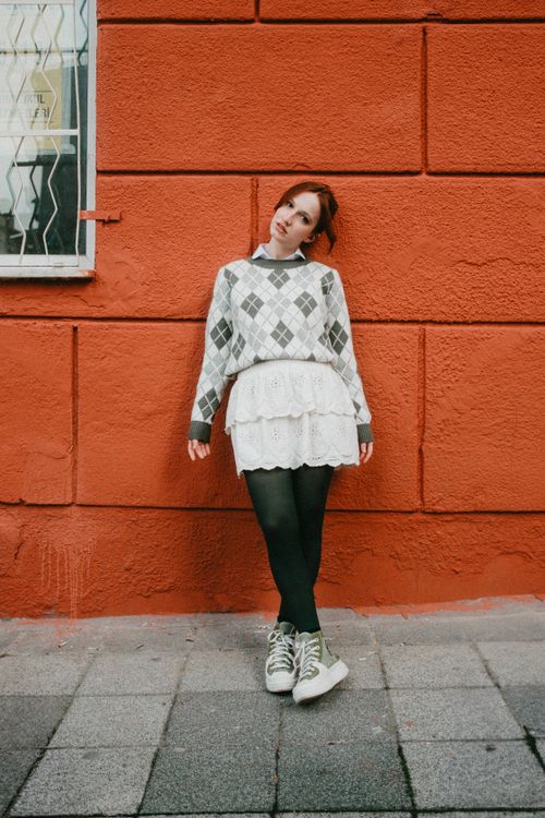 Woman in a sweater dress with white sneakers