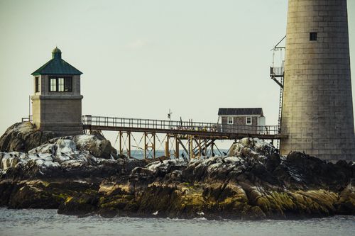 Free A scenic view of a lighthouse on rocky shores in Boston, MA. Stock Photo
