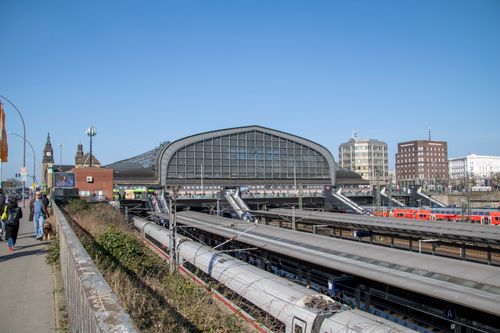Free View of Hamburg Central Station with clear blue skies and bustling activity. Stock Photo
