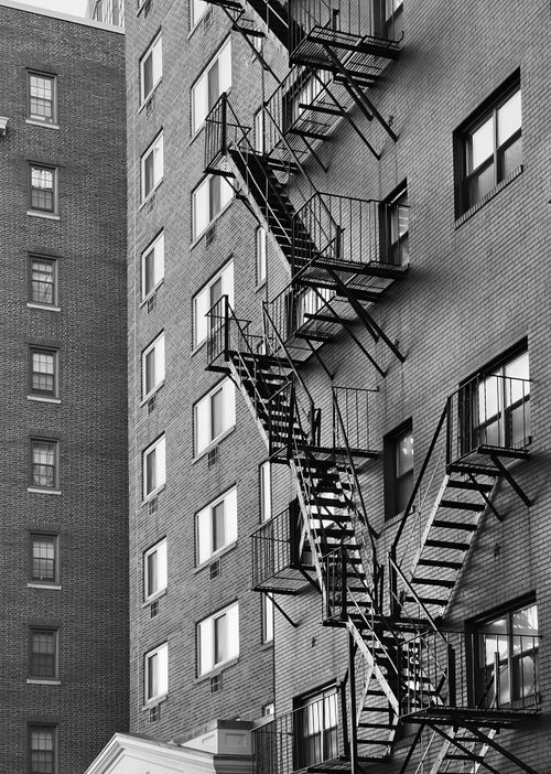 Free Monochrome image of a fire escape on a classic brick building facade. Stock Photo