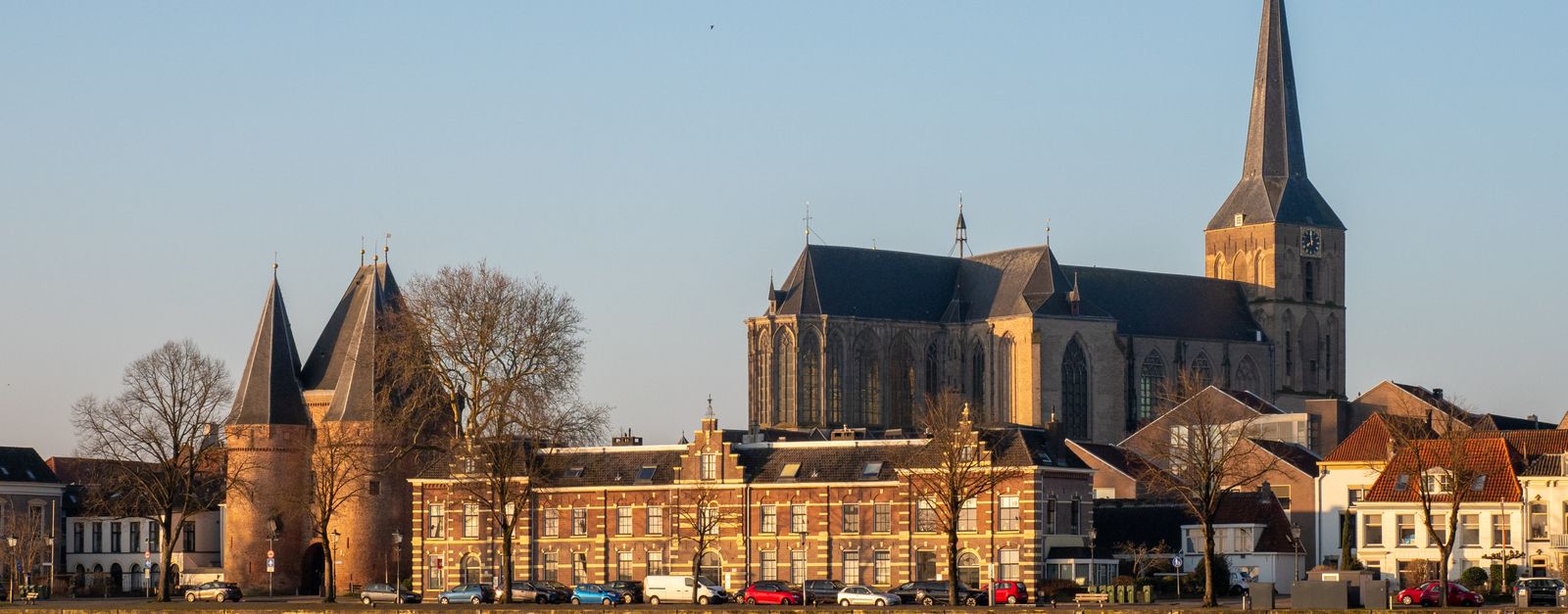 Beautiful view of a historic church and city gate in Kampen during daytime.