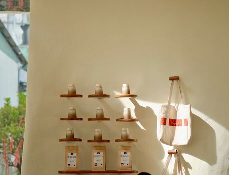 Wall-mounted shelves displaying coffee cups and bags, a touch of minimal cafe decor.