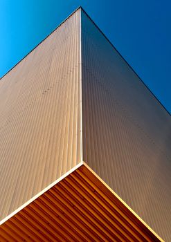 Minimalist modern architecture with clear blue sky, showcasing geometric design.