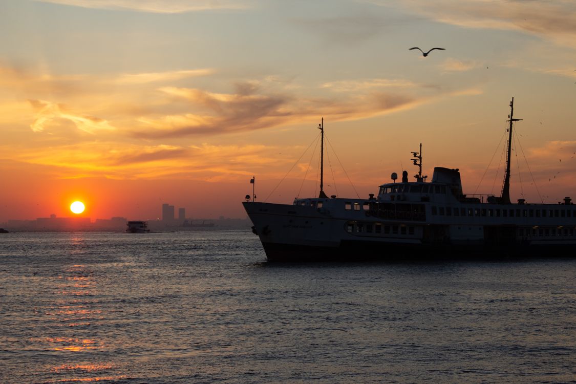 Scenic Sunset Over the Sea with Ferry Silhouette · Free Stock Photo